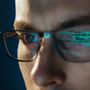 Close-up portrait of focused software engineer wearing eyeglasses